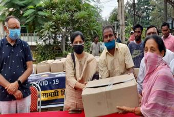 A beneficiary collects her COVID-19 relief grocery box