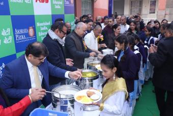Beneficiary children being served by dignitaries